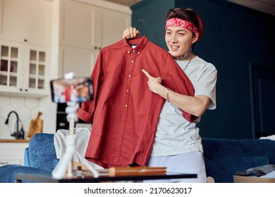 Happy Asian Man Blogger Broadcasting A Video For Selling Clothes Online