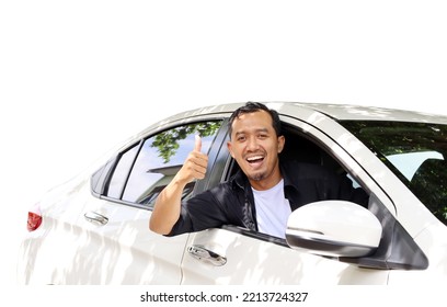Happy asian man in a car and showing thumbs up. Isolated on white background - Shutterstock ID 2213724327