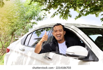 Happy Asian Man In A Car And Showing Thumbs Up.