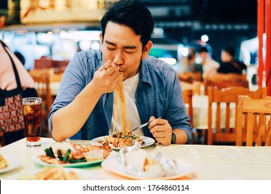 Happy Asian Man Eating Street Food At Local Market.