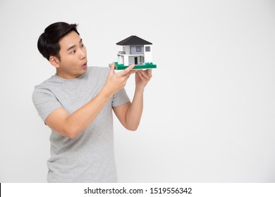 Happy Asian Man Holding Home Model, Planning To Take On A Large Loan For Purchase House Concept