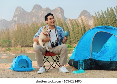 Happy Asian Man Playing With His Dog In The Park, Camping With Dog.