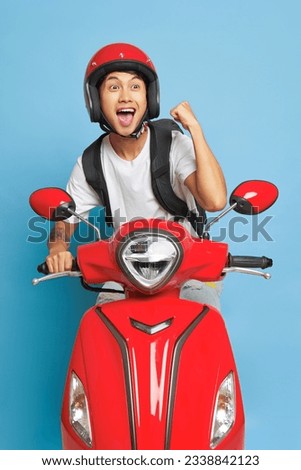 Happy Asian man in red helmet rides on red motor bike, smiling and enjoying life, delivery concept