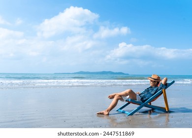 Happy Asian man relax and enjoy outdoor lifestyle travel ocean on summer holiday vacation. Handsome guy relaxing on sunbed at tropical island beach in sunny day. People and nature concept - Powered by Shutterstock