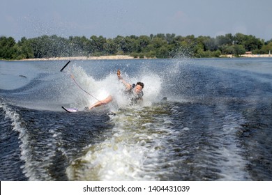 Happy Asian Man Riding Water Skis On Lake In Summer And Fall Down