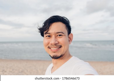 Happy Asian Man Selfie Himself While Walking On The Beach.