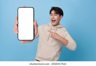 Happy Asian man showing and pointing finger to smartphone mockup of blank screen isolated on blue background. - Powered by Shutterstock