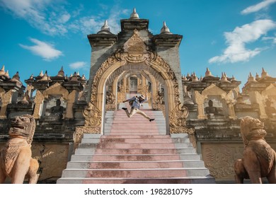 Happy Asian Man Traveler Jumping In The Attraction Beautiful Architecture Art Of South East Asian Culture. Travel South East Asia.