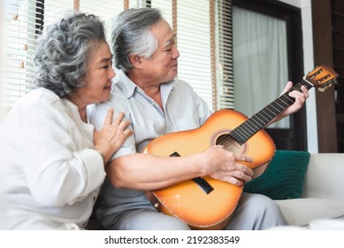 Happy Asian Mature Adult Couple Enjoying With Singing And Playing Guitar Together.