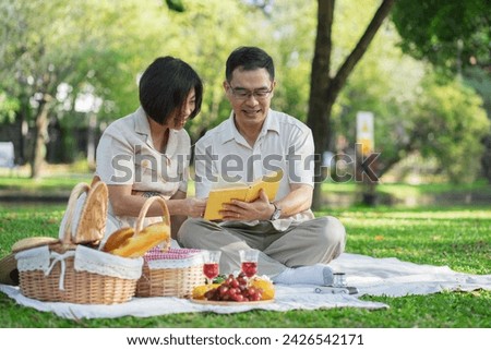 Happy asian middle aged couple in love on a romantic date outdoors in the summer at the par