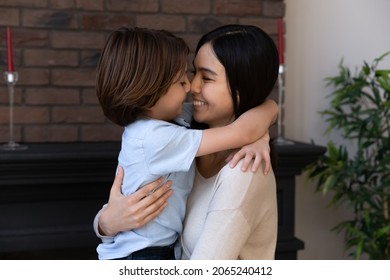 Happy Asian Mixed Race Mom Holding Son Boy In Arms, Hugging Kid With Noses Touch, Smiling, Enjoying Warm Moment. Younger Mum Carrying Kid And Dancing At Home. Motherhood, Adoption, Family Concept