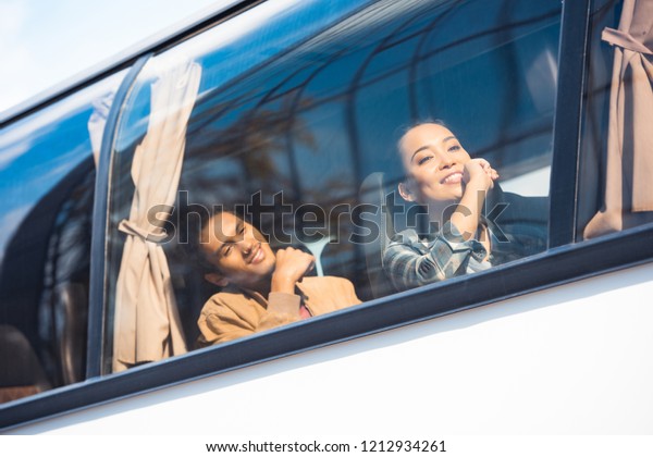 happy asian and mixed race tourists during trip on
travel bus