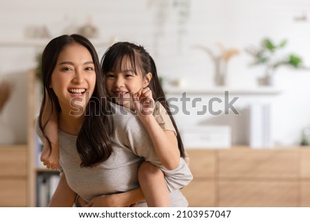Happy asian mom holding her daughter playing together at home.little girl hugging her mother smile and love having fun at home.Mother day concept