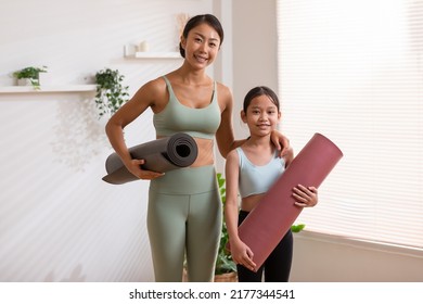 Happy Asian Mom And Little Girl Holding Yoga Mat Smile And Laughing Together Ready To Exercise Yoga At Home.2 Healthy Mother And Daughter Cheerful With Yoga Workout In Warmth Place.good Moment