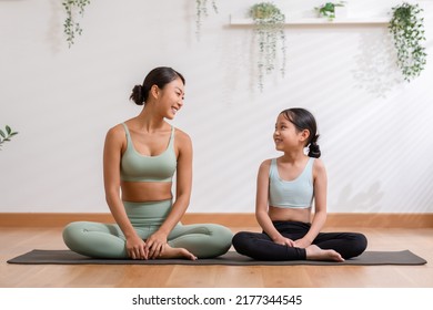 Happy Asian Mom And Little Girl Sitting On Yoga Mat Smile And Laughing Together Ready To Exercise Yoga At Home.2 Healthy Mother And Daughter Cheerful With Yoga Workout In Warmth Place.good Moment