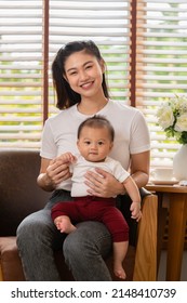 Happy Asian Mom Playing And Spending Time With Her Newborn Baby And Looking At Camera Together At Home.Adorable Baby Boy Smile Laughing With Mother In Warmth Place Relax And Comfortable.good Moment