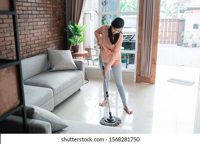 Happy Asian Mother Cleaning The Floor With Mop In The Room