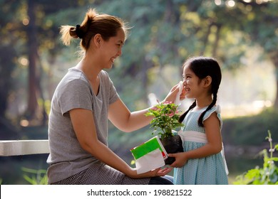 Happy Asian mother cleaning her daughter's face, Plant together - Powered by Shutterstock