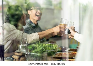 Happy Asian Multigenerational Family Of Dad Mom Daughter Girl And Grandfather Cheers Together During Lunch Meal Together With Joyful. Happy Family Engagement Togetherness Concept. Taken Outside Window