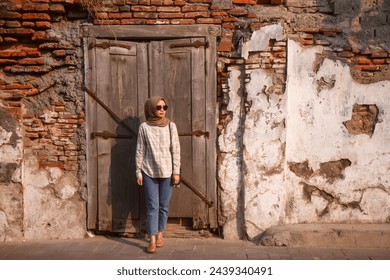 happy asian muslim woman roaming around kota lama or old city area, Semarang, Central Java , Indonesia. Traveling concept - Powered by Shutterstock