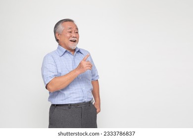 Happy Asian old man pointing to copy space blank space isolated on white background - Powered by Shutterstock