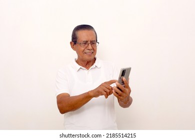 Happy Asian Old Man Standing While Pointing Or Using A Cell Phone. Isolated On White