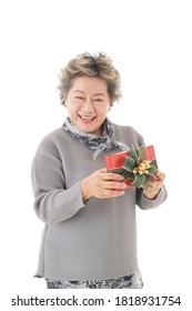 Happy Asian Old Woman Smiling And Holding Red Box Gift On White Background.