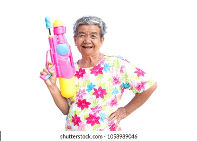 Happy Asian older woman playing water gun on white background, Songkran Festival in Thailand and summer season