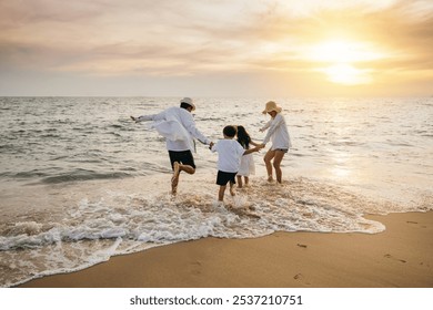 Happy Asian parents and daughters have delightful time on beach. Little girls bond with their mother and father running jumping and pretending to fly with arms wide open. Family fun under sun. - Powered by Shutterstock