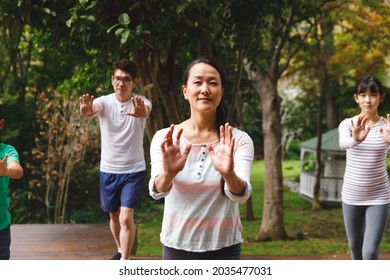 Happy asian parents, son and daughter exercising outdoors, practicing tai chi. family fitness time in garden. - Powered by Shutterstock