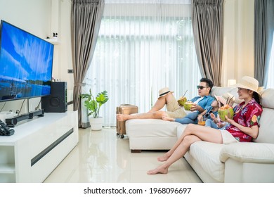 Happy Asian People Stay Home, Parents Spend Time With Children Due Covid-19 Lockdown. Family Traveller Watching TV Screen, Pretending They On Beach During Summer In House. Dream Vacation Trip Concept.