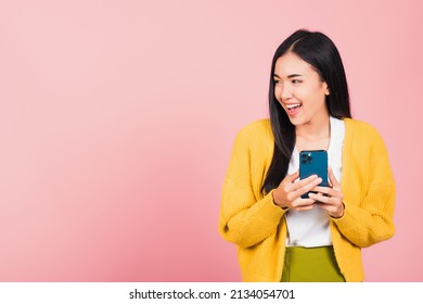 Happy Asian Portrait Beautiful Cute Young Woman Teen Smiling Excited Using Smart Mobile Phone Studio Shot Isolated On Pink Background, Thai Female Surprised Making Winner Gesture On Smartphone