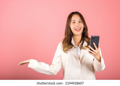 Happy Asian Portrait Beautiful Cute Young Woman Excited Holding Mobile Phone Blank Screen Presenting Product With Palm Of Hand At Empty, Studio Shot Isolated On Pink Background, Female Look Camera