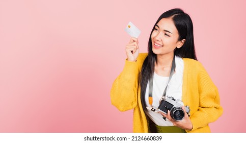 Happy Asian portrait beautiful young woman excited smiling photographer holding credit credit card bank and retro vintage photo camera ready travel isolated on pink background, tourism and vacation