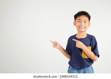 Happy Asian portrait cute young kid boy smiling indicate finger empty space, studio shot isolated on white background, Thai primary child pointing index out with copy space - Powered by Shutterstock