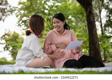 Happy Asian pregnant lesbian couple in the garden