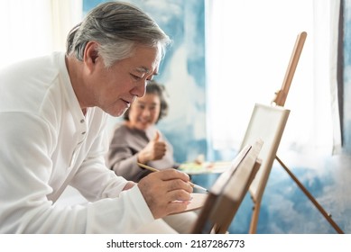 Happy Asian Senior adult Couple colouring on canvas together. - Powered by Shutterstock