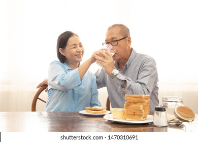 Happy Asian Senior Couple Cooking In Kitchen.