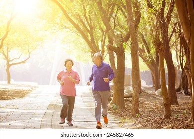 Happy Asian Senior Couple Exercising In The Park