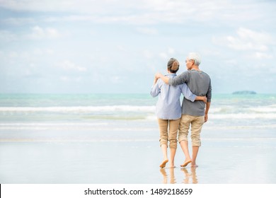 Senior Couple Walking On Beach Holding Stock Photo (Edit Now) 1518503288