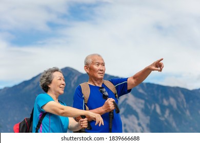 Happy Asian Senior Couple Hiking In Nature 