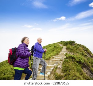 Happy Asian Senior Couple Hiking On The Mountain