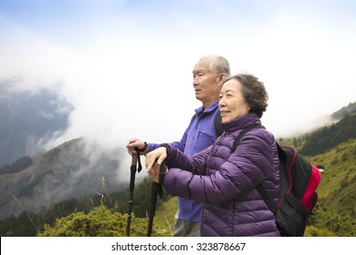 Happy Asian Senior Couple Hiking On The Mountain