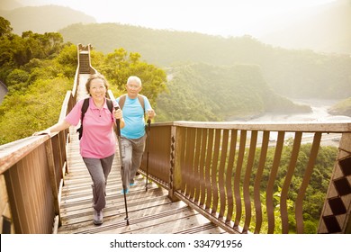 Happy  Asian Senior Couple Hiking On The Mountain 