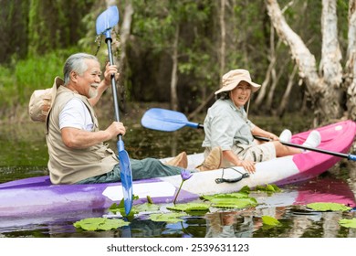 Happy Asian senior couple kayaking in the river on summer holiday vacation. Healthy retired elderly people enjoy and fun outdoor active lifestyle travel nature, sport and rowing a boat in the lake. - Powered by Shutterstock