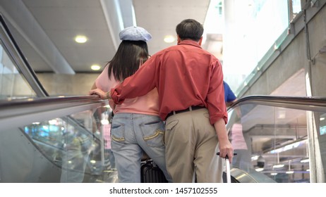 Happy asian senior couple with luggage walking on escalator together in airport waiting for departure at  terminal . Elderly Journey. older lovers . travel. flight. retired . vacation. rear back view - Powered by Shutterstock