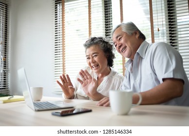 Happy Asian Senior Couple Making Video Call With Their Family By A Laptop Computer Technology.