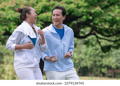 Happy Asian senior couple running exercising outdoors at park in morning - Powered by Shutterstock