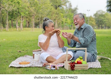 Happy asian senior man and woman sitting on blanket and having fun   on picnic together in garden outdoor. Lover couple eating food and embracing at the park. Happiness marriage lifestyle concept. - Powered by Shutterstock