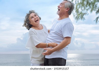 Happy Asian Senior Retired Couple, Relax Smiling Elder Man And Woman Enjoying With Retired Vacation At Sea Beach Outdoor. Health Care, Family Outdoor Lifestyle